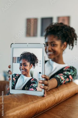 Beautiful teen girl taking selfie with tablet photo