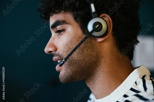 Hispanic man with headset speaking with client