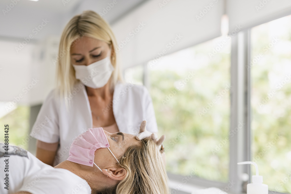 Female doctor preparing eyes for a micropigmentation intervention. Female doctor preparing eyes for a micropigmentation intervention.