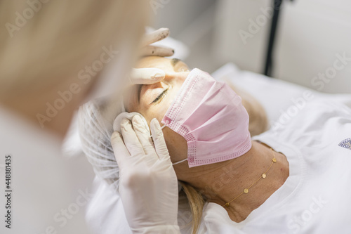 Female doctor preparing eyes for a micropigmentation intervention. photo