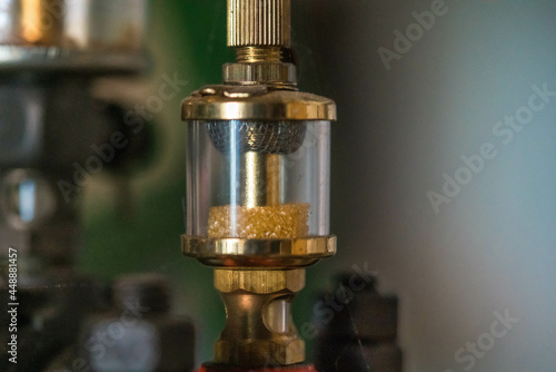Closeup shot of a gravity feed oiler on a blurred background
