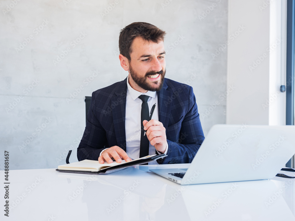 Confident smiling young office worker talking in online call, making notes, writing down ideas. Confident smiling young office worker talking in online call, making notes, writing down ideas.