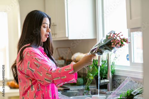 Happy woman decorating home with floral bouquets photo