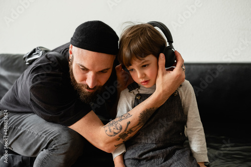 A Berliner Guy And A Little Kid Are Listening To Some Music  photo