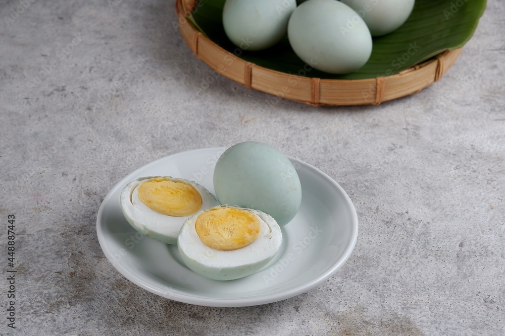 whole and half salted egg,on white rustic background whole and half salted egg,on white rustic background