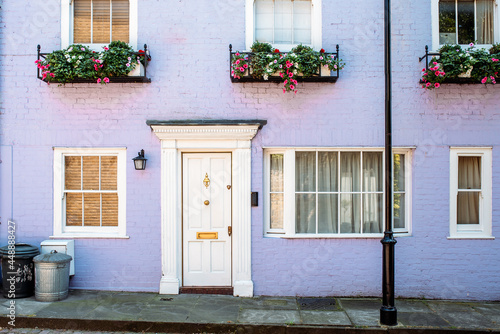 Beautiful lilac house facade with flowers on the windows