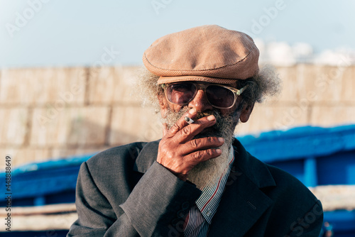 Portrait of a stylish old man smoking a cigarette photo