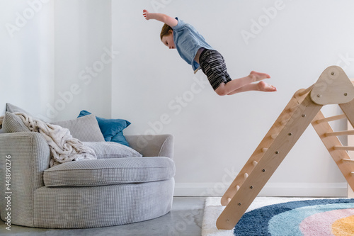 Child jumping from pikler triangle photo