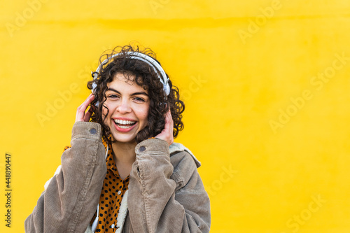 portrait of young smiley woman listening to music photo