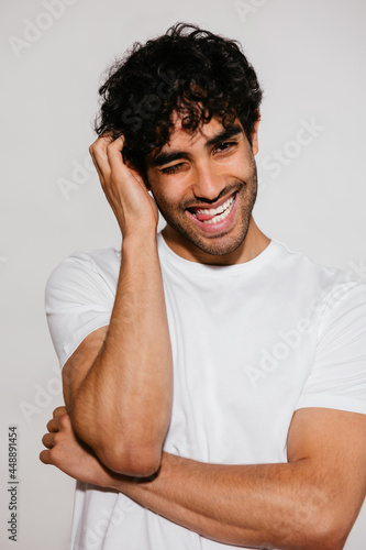 Playful Hispanic man touching hair photo