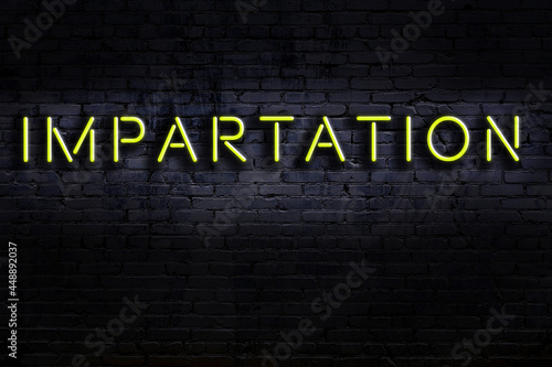Neon sign. Word impartation against brick wall. Night view