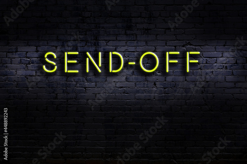 Night view of neon sign on brick wall with inscription send-off photo