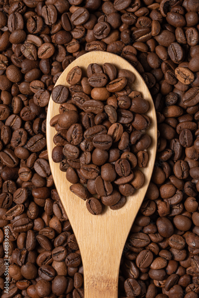 Fototapeta premium Coffee beans on wooden spoon close-up