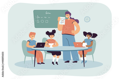 Teacher showing children pictures with geometric shapes. Flat vector illustration. Children sitting in classroom at table with laptops, studying Geometry. Learning, education, school concept