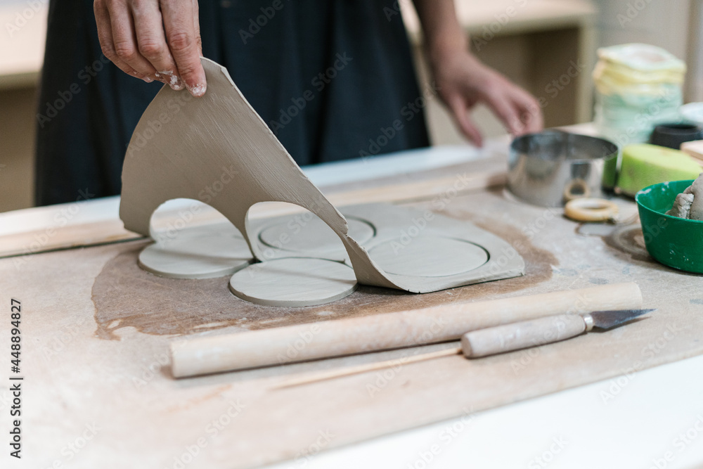 Crop potter cutting circles from clay Crop potter cutting circles from clay