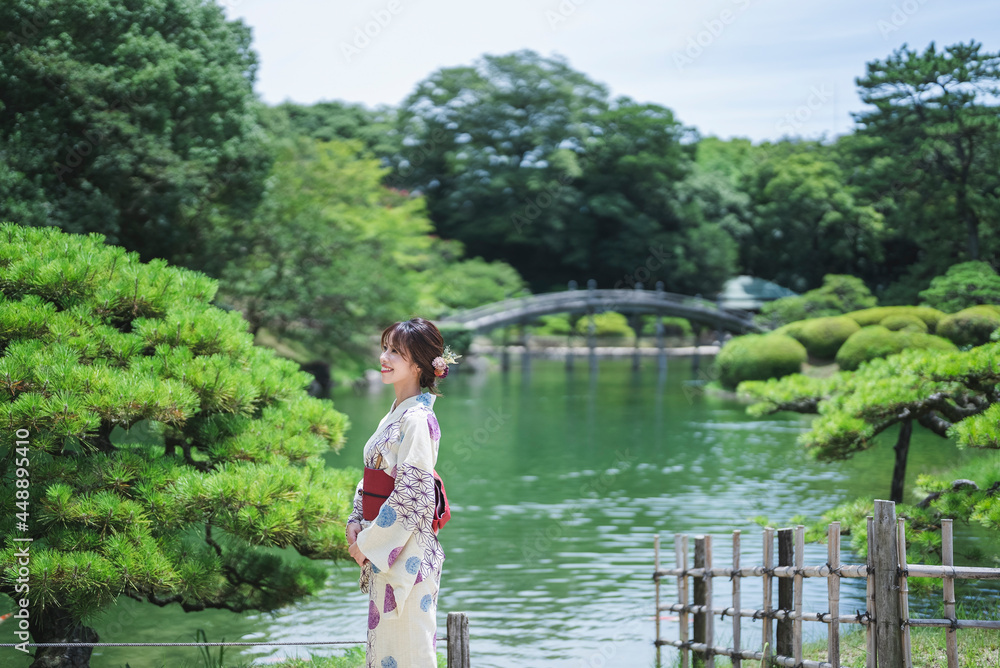 Fototapeta premium 日本庭園を散策する浴衣の女性