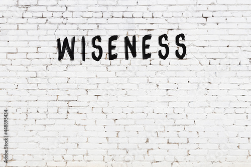 Foto White wall with black paint inscription wiseness on it
