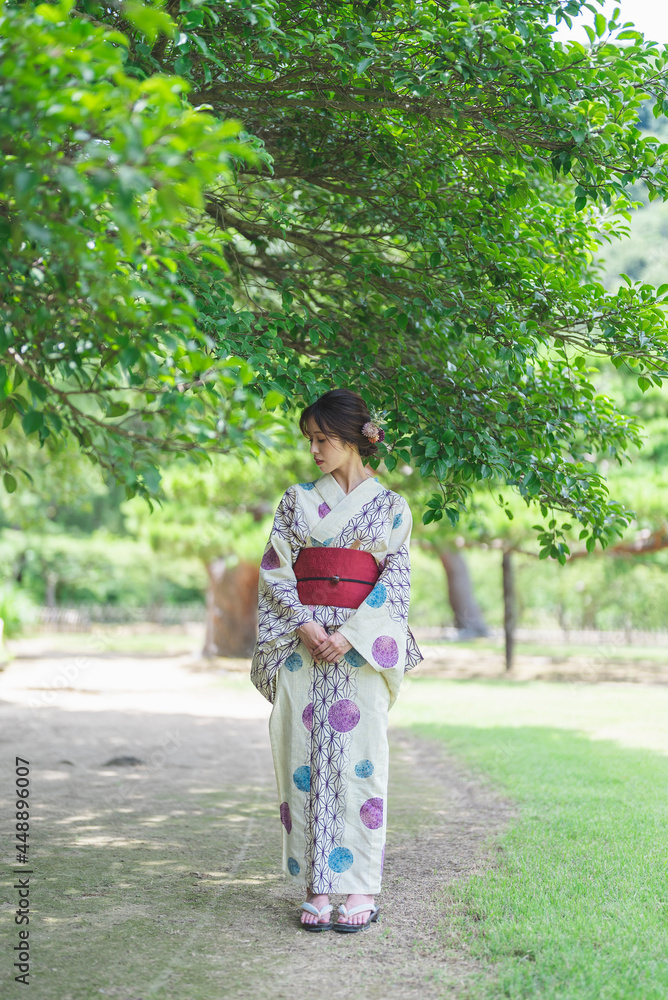 日本庭園を散策する浴衣の女性