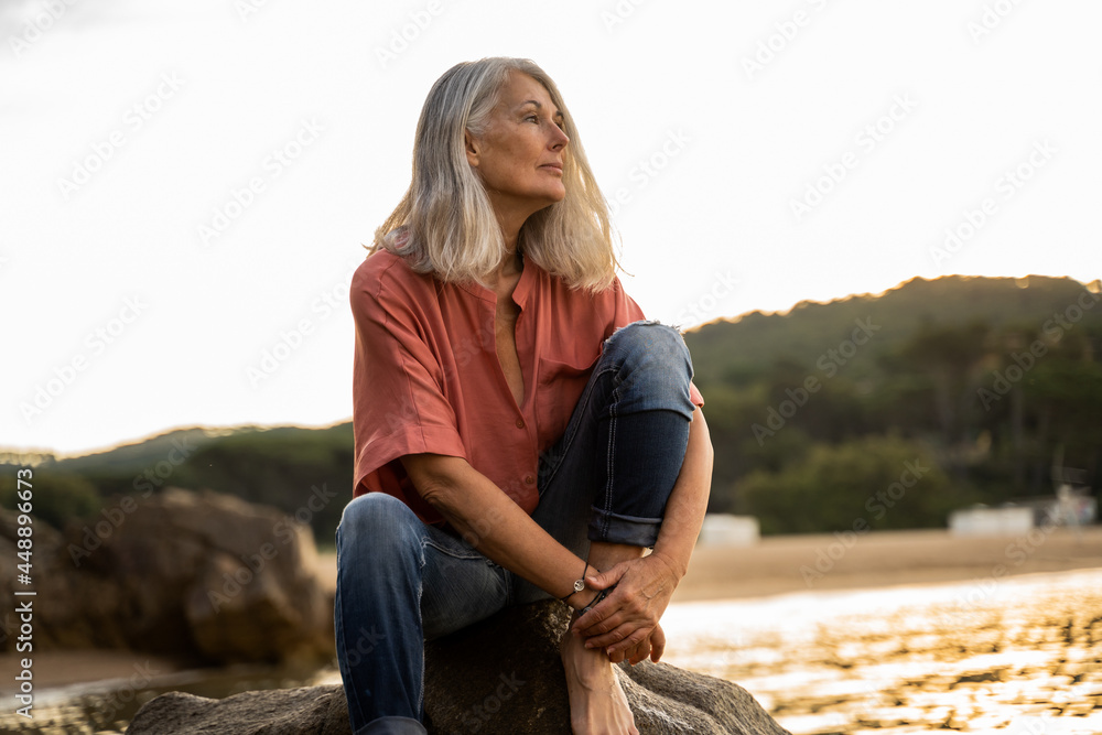 Pensive Beautiful mature woman relaxing at beach Pensive Beautiful mature woman relaxing at beach