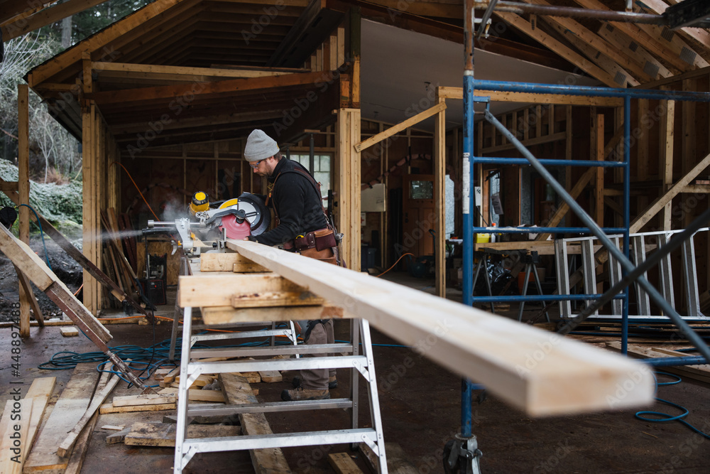 Carpenter working with saw on the job site in winter Carpenter working with saw on the job site in winter