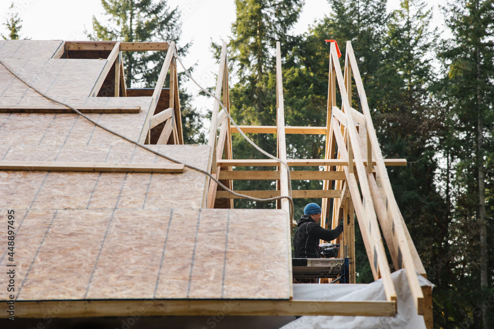 Man working on the roof doing construction in winter