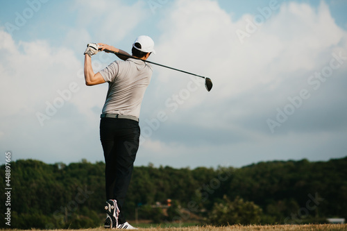 Golfers take the swing shot with a strong stance. looking from behind. © nitinai2518
