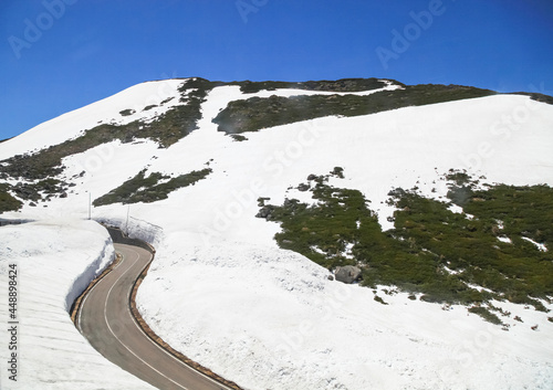 Tateyama Kurobe Alpine Route with beautiful landscape snow mountains., the tourists bus move along the japan alps snow wall with blue sky background. Toyama city, Japan. photo