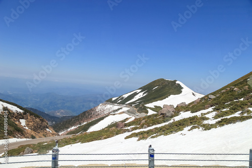Tateyama Kurobe Alpine Route with beautiful landscape snow mountains., the tourists bus move along the japan alps snow wall with blue sky background. Toyama city, Japan.