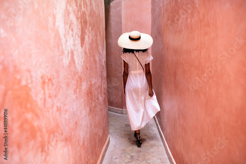 Woman walking through clay walls in marrakesh photo