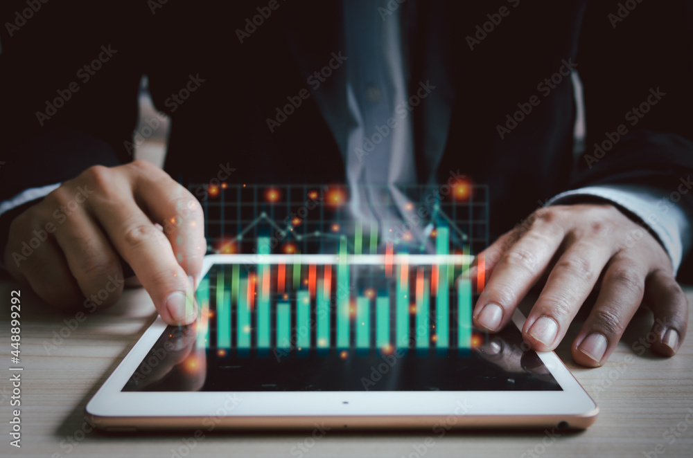 Business man tablet virtual screen stock graph and charts.Business digital marketing finance and investment concept. Business man tablet virtual screen stock graph and charts.Business digital marketing finance and investment concept.