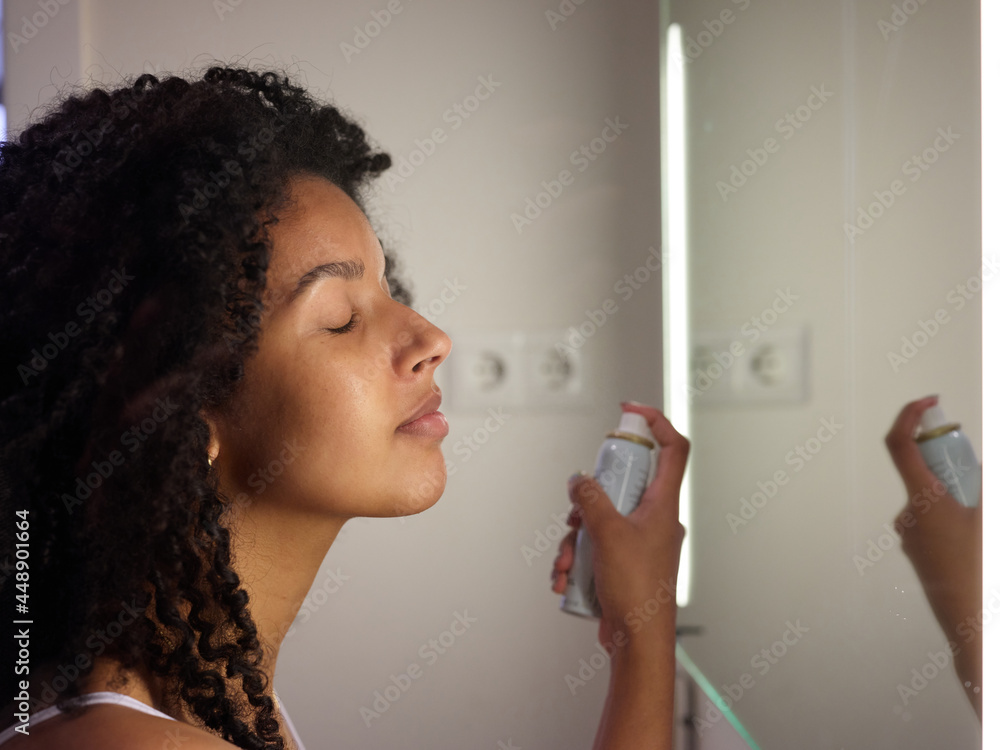 Woman using refreshing face spray. Woman using refreshing face spray.