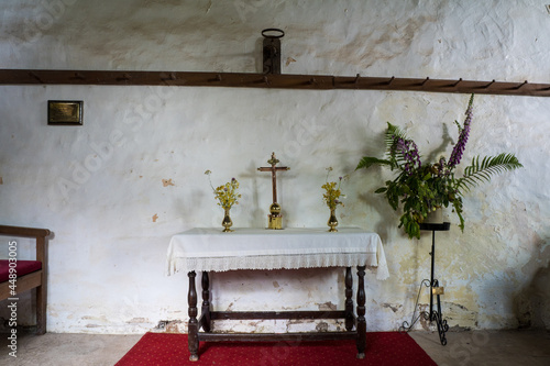 A small alter and cross in a historic medieval church. photo