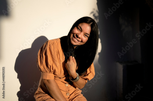 Young brunette woman smiling with fashion dress at home photo