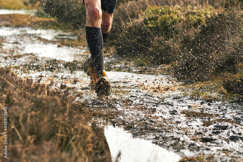 Trail runner splashes through muddy track 