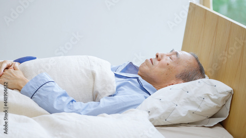 ベッドで寝ているシニア男性