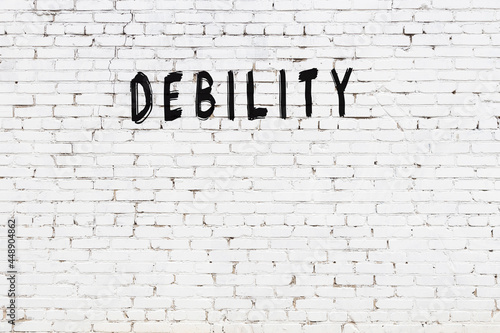 Картината върху платно White wall with black paint inscription debility on it