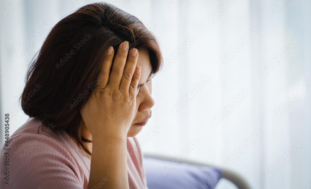 Middle age senior Asian woman feeling pain from sudden headache and brain stroke attack and hold her head with a stressed face. Concept of brain and head problem Middle age senior Asian woman feeling pain from sudden headache and brain stroke attack and hold her head with a stressed face. Concept of brain and head problem