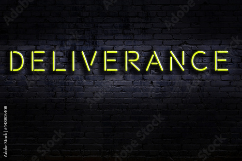 Photos Night view of neon sign on brick wall with inscription deliverance