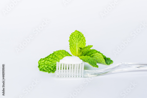 Toothbrush toothpaste and peppermint on white background.