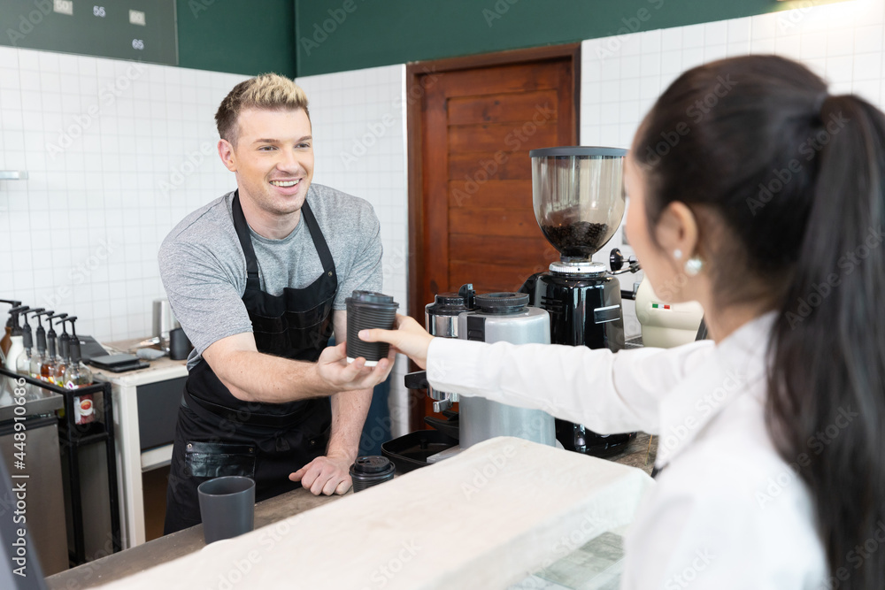 male barista giving a cup of coffee to customer in cafe or coffee shop