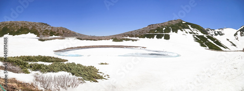 Tateyama Kurobe Alpine Route with beautiful landscape snow mountains., the tourists bus move along the japan alps snow wall with blue sky background. Toyama city, Japan.