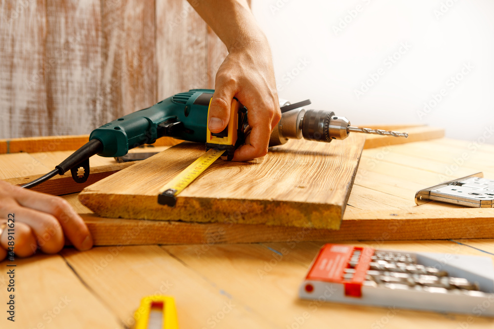 Handyman in blue uniform works with electricity automatic screwdriver. House renovation conception. Handyman in blue uniform works with electricity automatic screwdriver. House renovation conception.