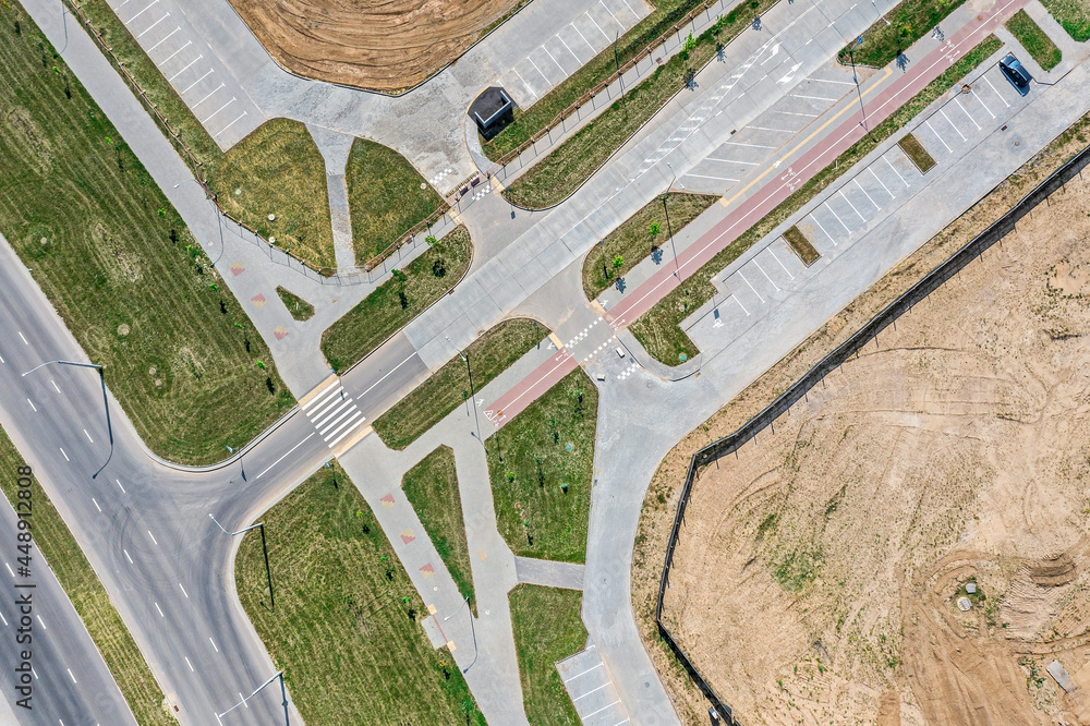 Fototapeta premium road intersection, sidewalk and parking lots, view from above with drone. newly constructed urban road