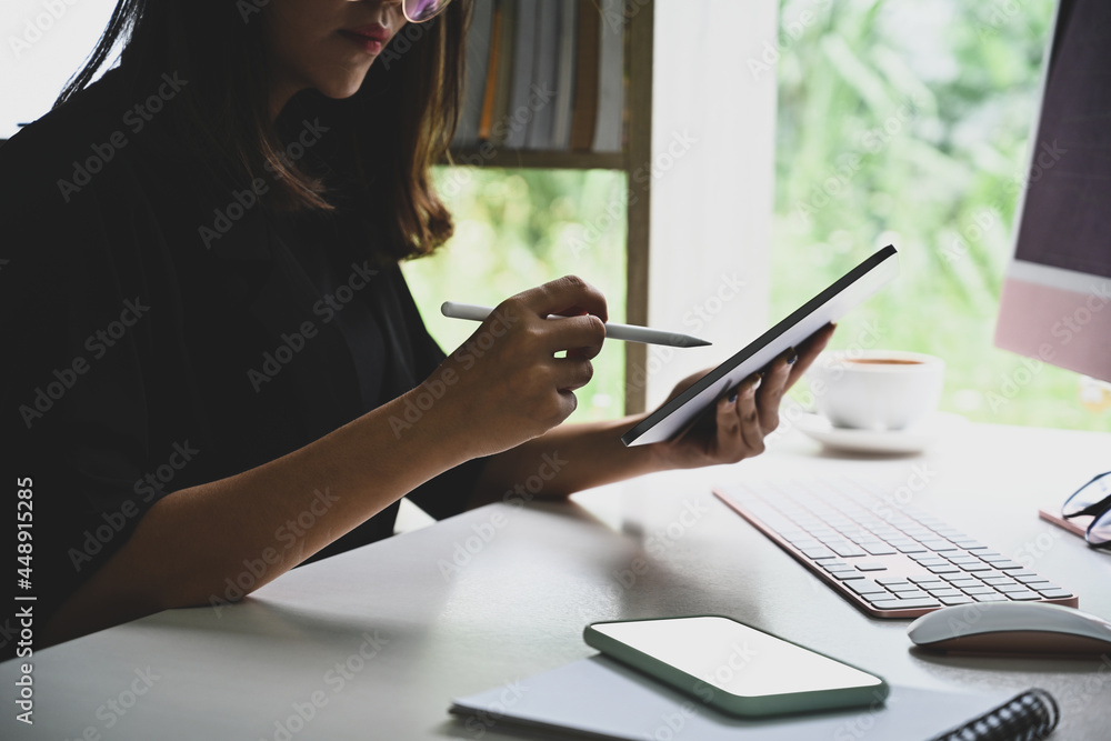 Young businesswoman using digital tablet at office desk. Young businesswoman using digital tablet at office desk.