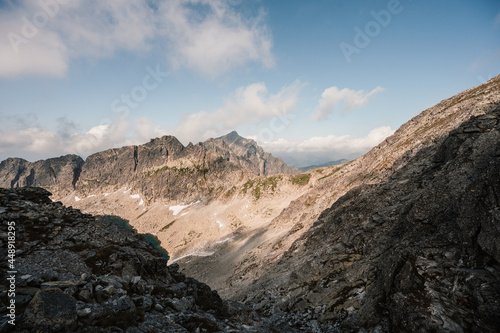 Mountain valley full of  lake and blooming flowers and a sidewalk leading to the valley. High Tatras national park , Mlynicka dolina, Slovakia landscape. photo