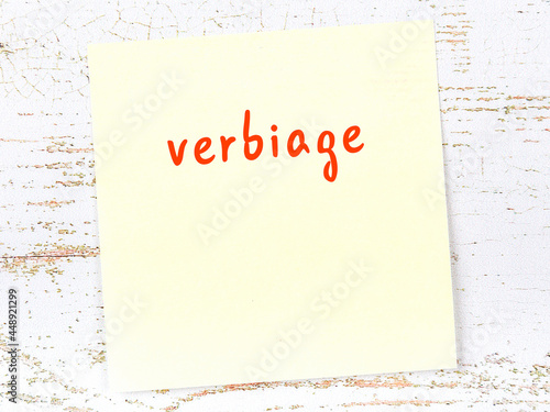 Obraz na płótnie Yellow sticky note on wooden wall with handwritten word verbiage