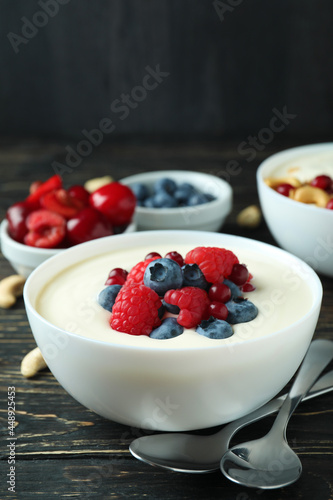 Concept of tasty breakfast with yogurt on wooden table