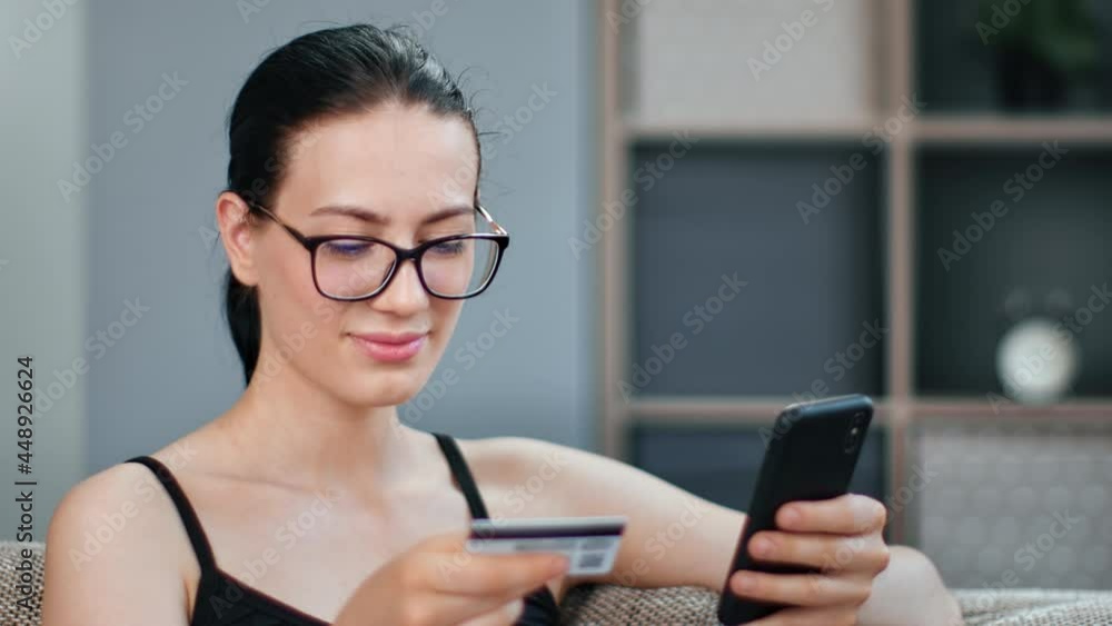 Pleasant mixed race woman paying card use online smartphone application enjoying internet shopping Pleasant mixed race woman paying card use online smartphone application enjoying internet shopping