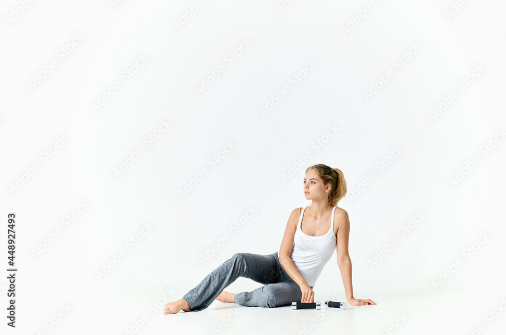 woman in sports uniform sitting on the floor dumbbells exercise workout gym