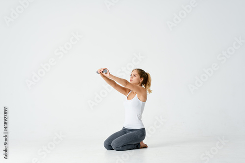 woman sitting barefoot on the floor dumbbells in hands exercise muscles workout